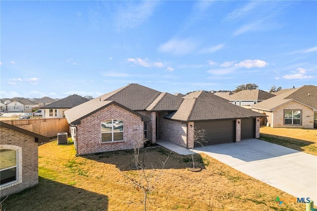 single story home with cooling unit, a garage, and a front yard