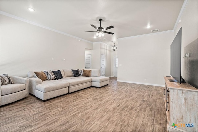 living room featuring hardwood / wood-style flooring, crown molding, and ceiling fan