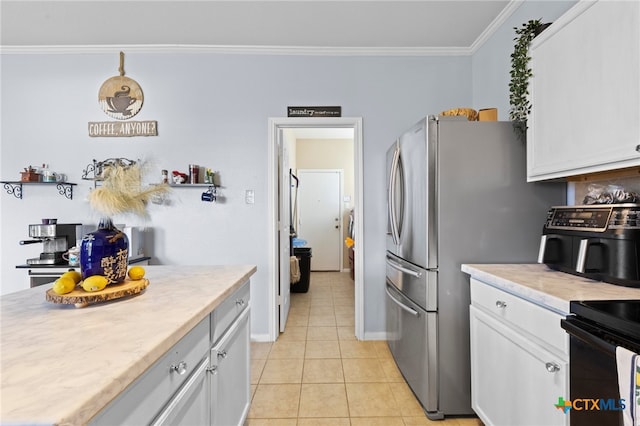 kitchen with white cabinetry, crown molding, stainless steel fridge, and light tile patterned flooring