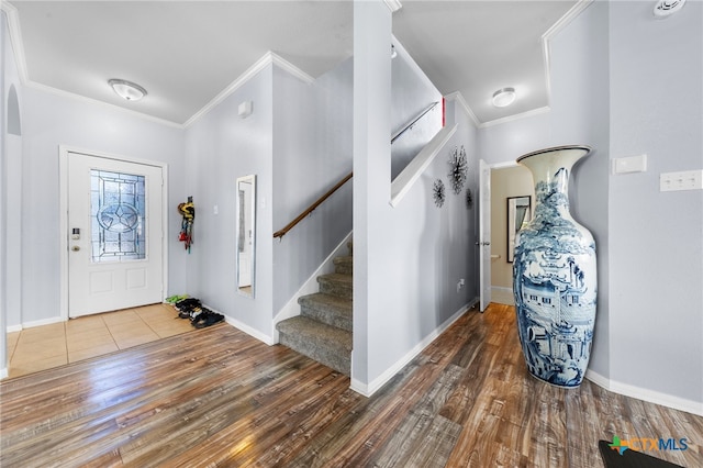 entryway with ornamental molding and dark wood-type flooring