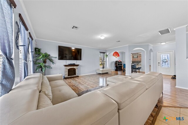 living room featuring a healthy amount of sunlight, ornamental molding, and hardwood / wood-style floors