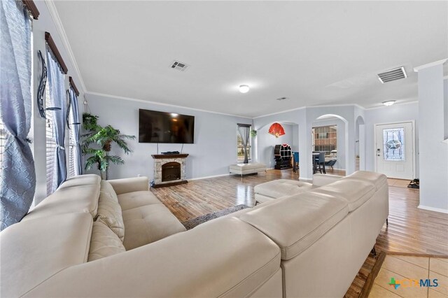 413 E Orion Dr, Killeen, TX 76542 - living area with ornamental molding, arched walkways, baseboards, a fireplace, and light wood finished floors
