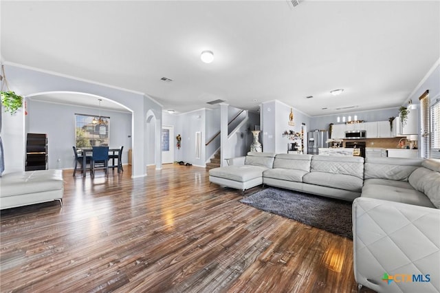 413 E Orion Dr, Killeen, TX 76542 - living area with arched walkways, wood finished floors, stairway, ornamental molding, and baseboards