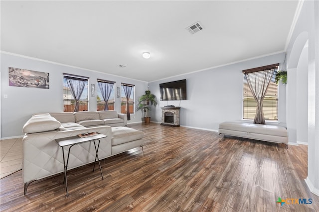 living room featuring dark wood-type flooring and crown molding