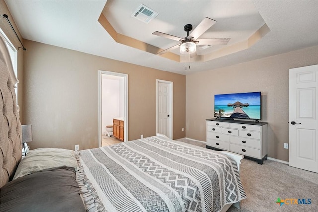 2606 Wesley Dr, Killeen, TX 76549 - bedroom featuring a raised ceiling, light colored carpet, a ceiling fan, and ensuite bathroom