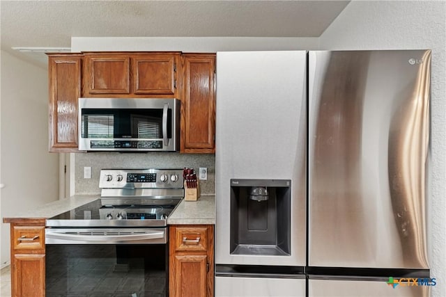 2606 Wesley Dr, Killeen, TX 76549 - kitchen with stainless steel appliances, light countertops, and brown cabinets