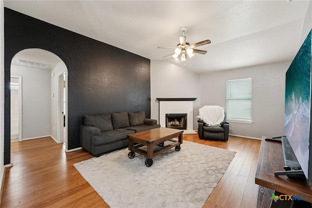 2606 Wesley Dr, Killeen, TX 76549 - living room featuring arched walkways, a ceiling fan, wood finished floors, and a fireplace