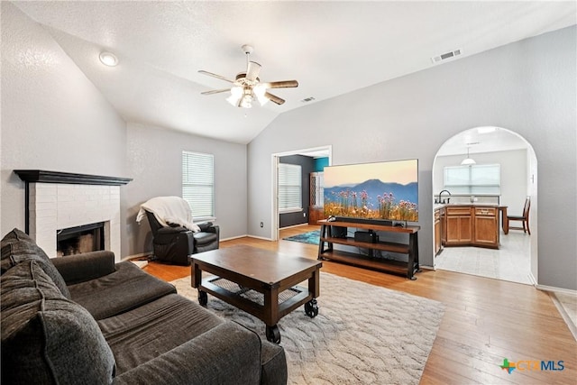 2606 Wesley Dr, Killeen, TX 76549 - living area with a ceiling fan, light wood finished floors, lofted ceiling, arched walkways, and a fireplace