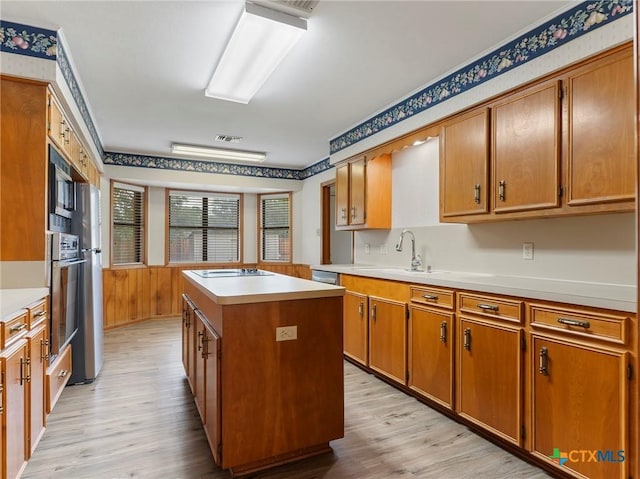 kitchen featuring light wood-type flooring, light countertops, electric stovetop, and a kitchen island