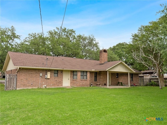 rear view of house with a lawn, a chimney, a patio area, and brick siding