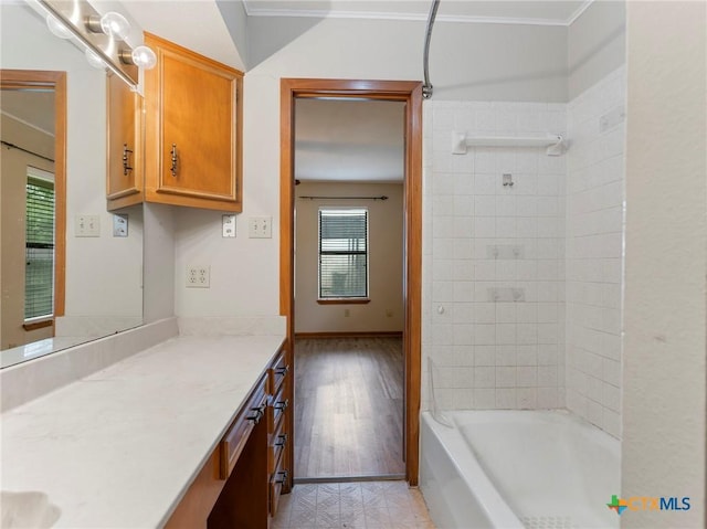 bathroom featuring shower / bathing tub combination, vanity, plenty of natural light, and ornamental molding