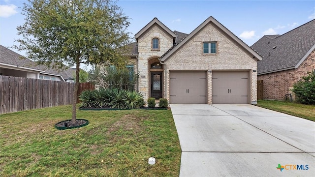 french country style house with a front yard and a garage