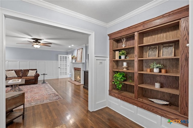 interior space with ceiling fan, crown molding, and dark hardwood / wood-style flooring