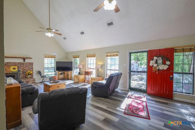 living room featuring a fireplace, a textured ceiling, ceiling fan, and hardwood / wood-style floors