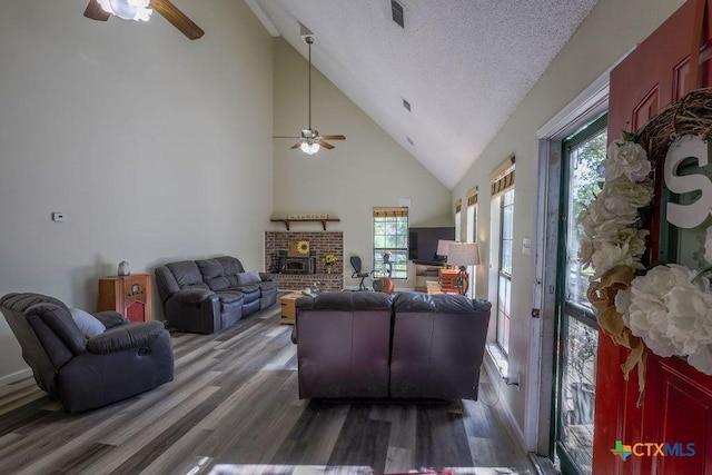 living room featuring a textured ceiling, ceiling fan, and dark hardwood / wood-style floors