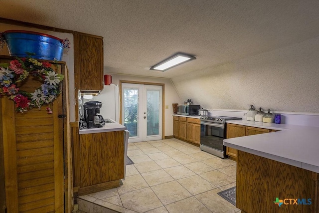 kitchen featuring stainless steel appliances, light tile patterned floors, french doors, a textured ceiling, and lofted ceiling