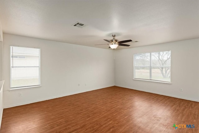 empty room with hardwood / wood-style flooring and ceiling fan