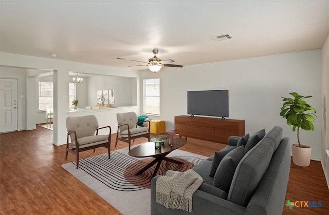 living room with hardwood / wood-style flooring, plenty of natural light, and ceiling fan with notable chandelier