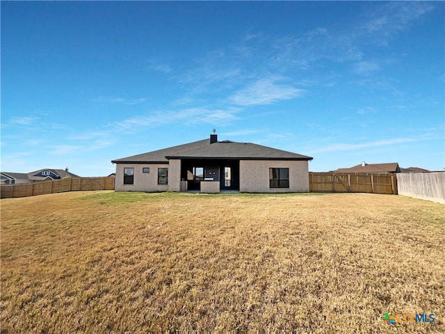 rear view of property featuring a lawn