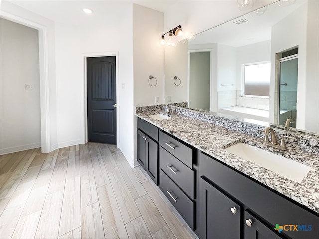 bathroom featuring vanity, hardwood / wood-style flooring, and independent shower and bath