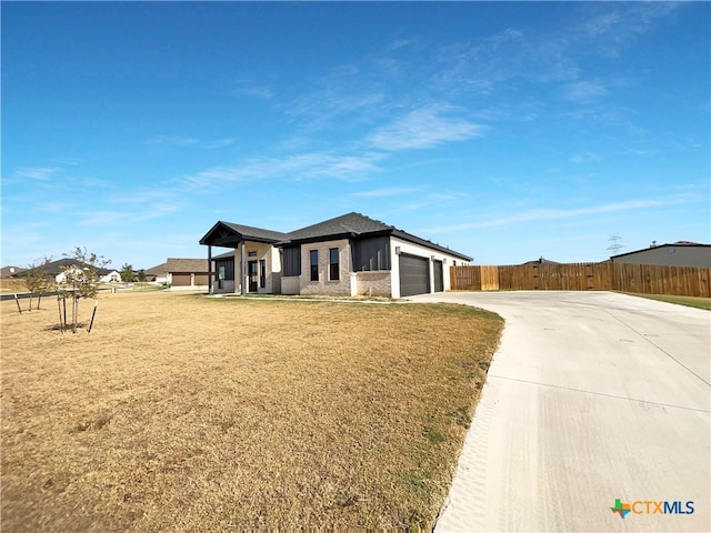 prairie-style home featuring a garage and a front lawn