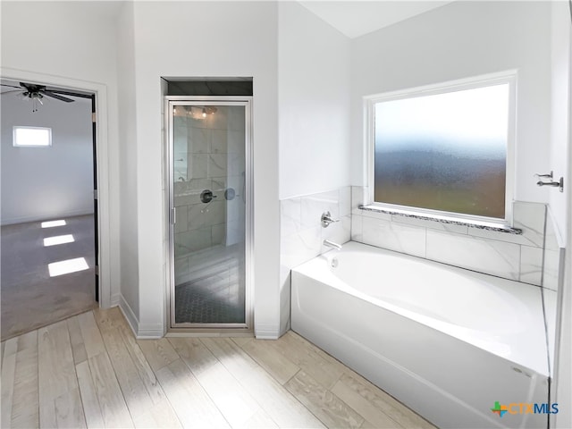 bathroom with hardwood / wood-style floors, ceiling fan, and separate shower and tub