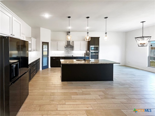 kitchen featuring white cabinets, black appliances, a kitchen island with sink, and decorative light fixtures