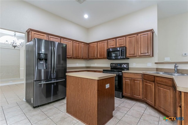 kitchen featuring light tile patterned floors, light countertops, appliances with stainless steel finishes, brown cabinetry, and a sink