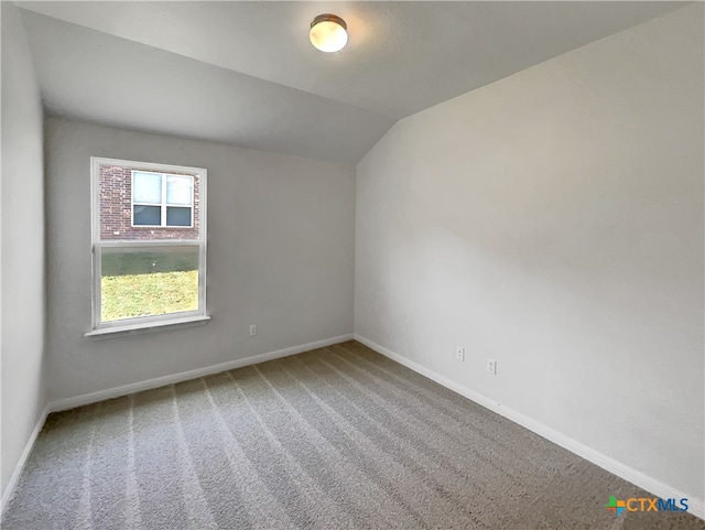 unfurnished room featuring lofted ceiling and carpet floors