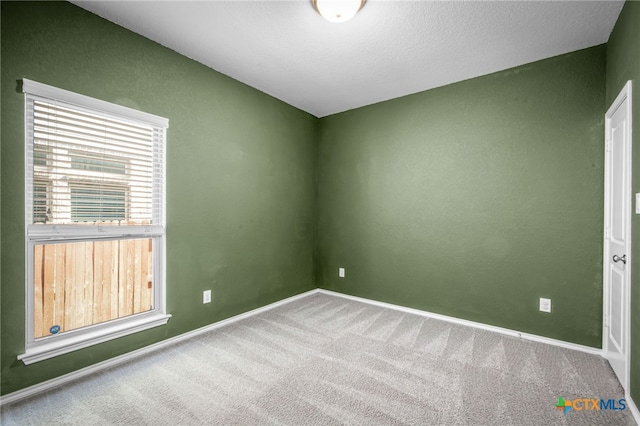unfurnished room with baseboards and carpet floors