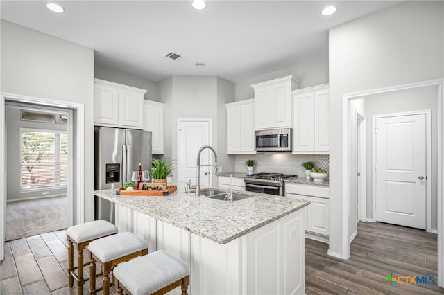 kitchen with a sink, tasteful backsplash, appliances with stainless steel finishes, and white cabinets