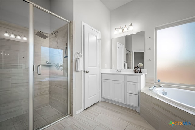 full bathroom with a stall shower, vanity, and a bath
