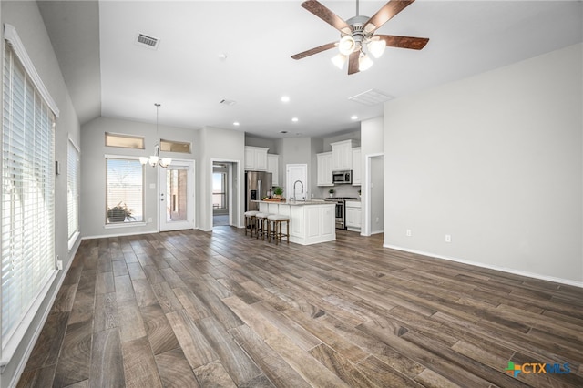 unfurnished living room featuring dark wood finished floors, visible vents, ceiling fan with notable chandelier, and a sink