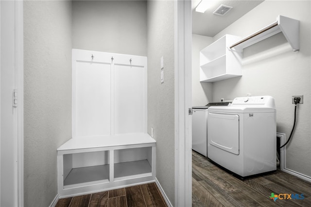 clothes washing area featuring visible vents, baseboards, laundry area, dark wood-style floors, and washer and dryer