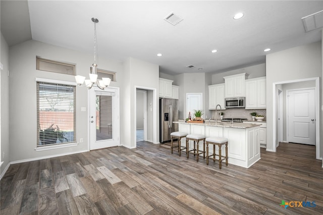 kitchen featuring visible vents, stainless steel appliances, and dark wood-style flooring