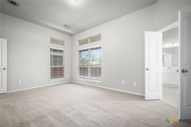 spare room featuring baseboards, visible vents, and carpet floors
