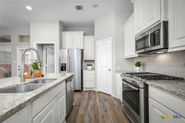 kitchen with visible vents, dark wood-style flooring, a sink, stainless steel appliances, and white cabinets