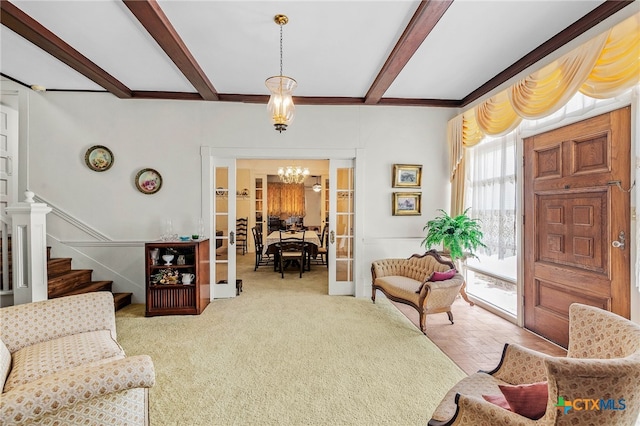 carpeted living room featuring french doors, beamed ceiling, and a chandelier