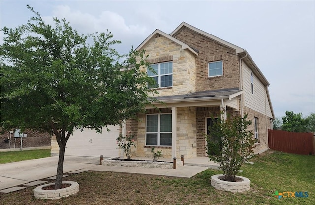 traditional home with stone siding, driveway, fence, and a front yard