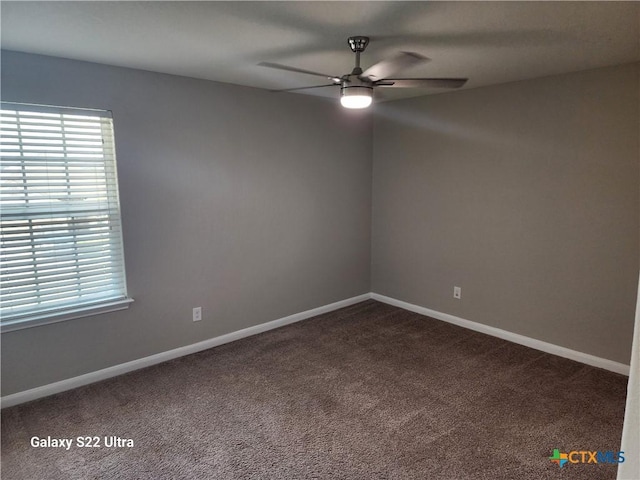 empty room with dark carpet, baseboards, and ceiling fan