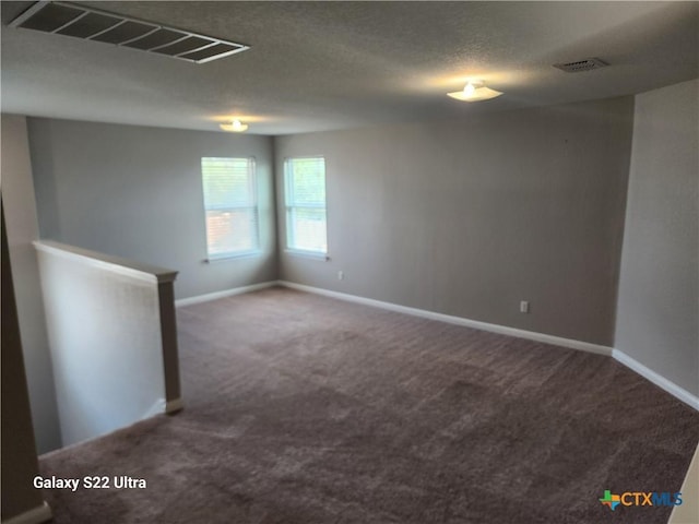 spare room with baseboards, visible vents, and carpet