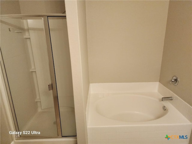 bathroom with a garden tub and a stall shower