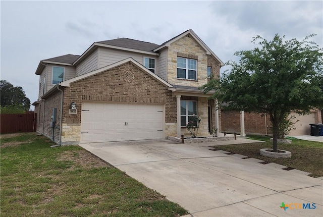 view of front of property with concrete driveway, stone siding, an attached garage, fence, and a front yard