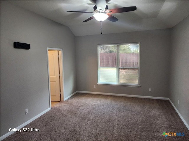 unfurnished room featuring lofted ceiling, a ceiling fan, baseboards, and carpet
