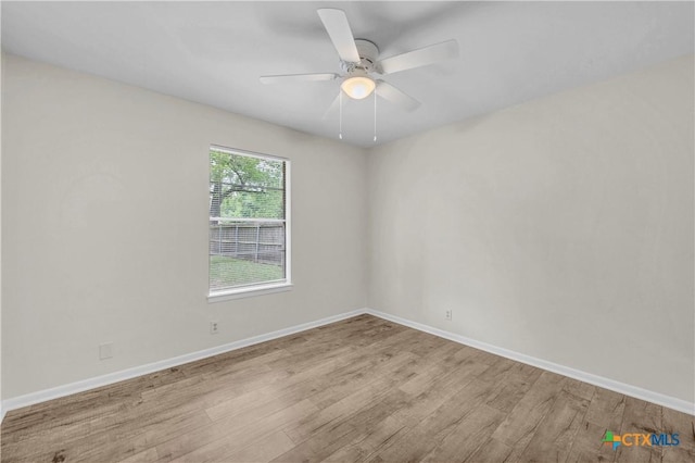 spare room featuring baseboards, a ceiling fan, and wood finished floors