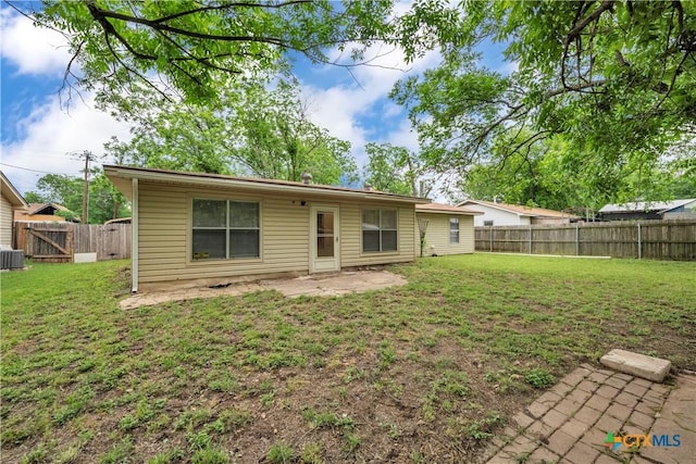 back of property featuring a fenced backyard, a yard, and cooling unit