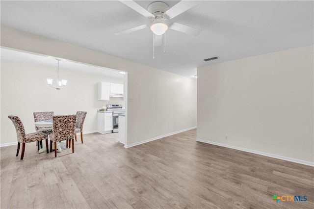 dining space with baseboards, visible vents, light wood-style flooring, and ceiling fan with notable chandelier