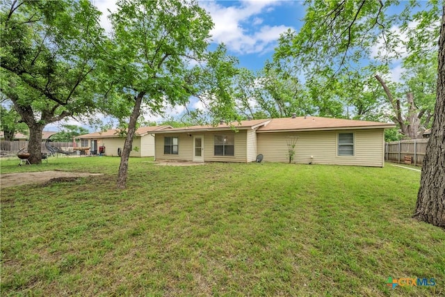 back of house featuring a lawn and a fenced backyard