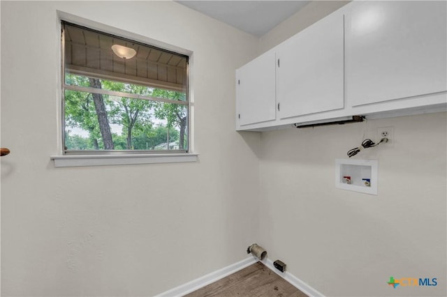 laundry area featuring baseboards, washer hookup, cabinet space, and wood finished floors