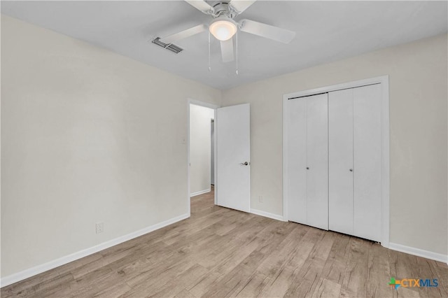 unfurnished bedroom featuring visible vents, baseboards, wood finished floors, and a closet